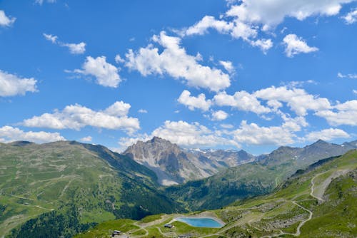 An Aerial Photography of a Lake Between Mountains Under the Blue Sky and White Clouds