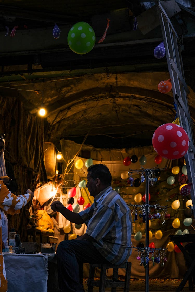 Man Selling Balloons By An Illuminated Arch