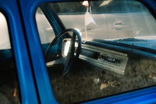 Free Explore the classic vintage interior of a blue car, featuring dashboard details and steering wheel. Stock Photo