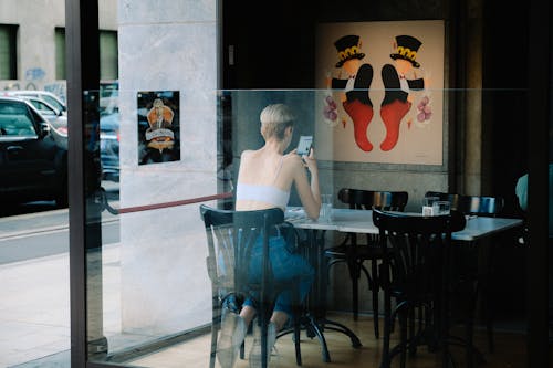 Woman Using a Phone in a Cafe