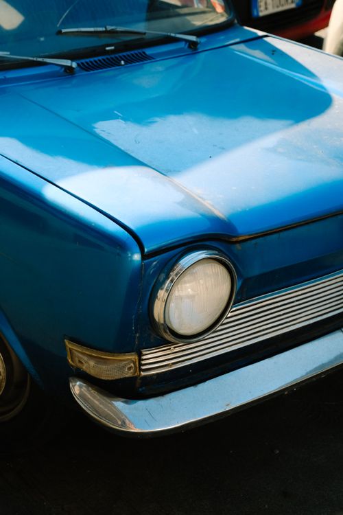 Free Detailed shot of a vintage blue car hood showcasing classic design elements and chrome accents. Stock Photo