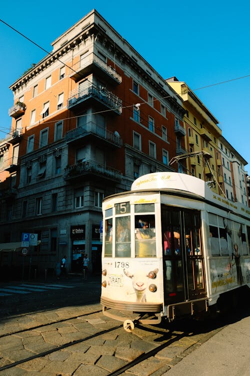 White Tram in the City Near Concrete Building