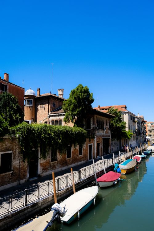 Free Serene canal view showcasing docked boats and historic buildings in Venice, Italy. Stock Photo