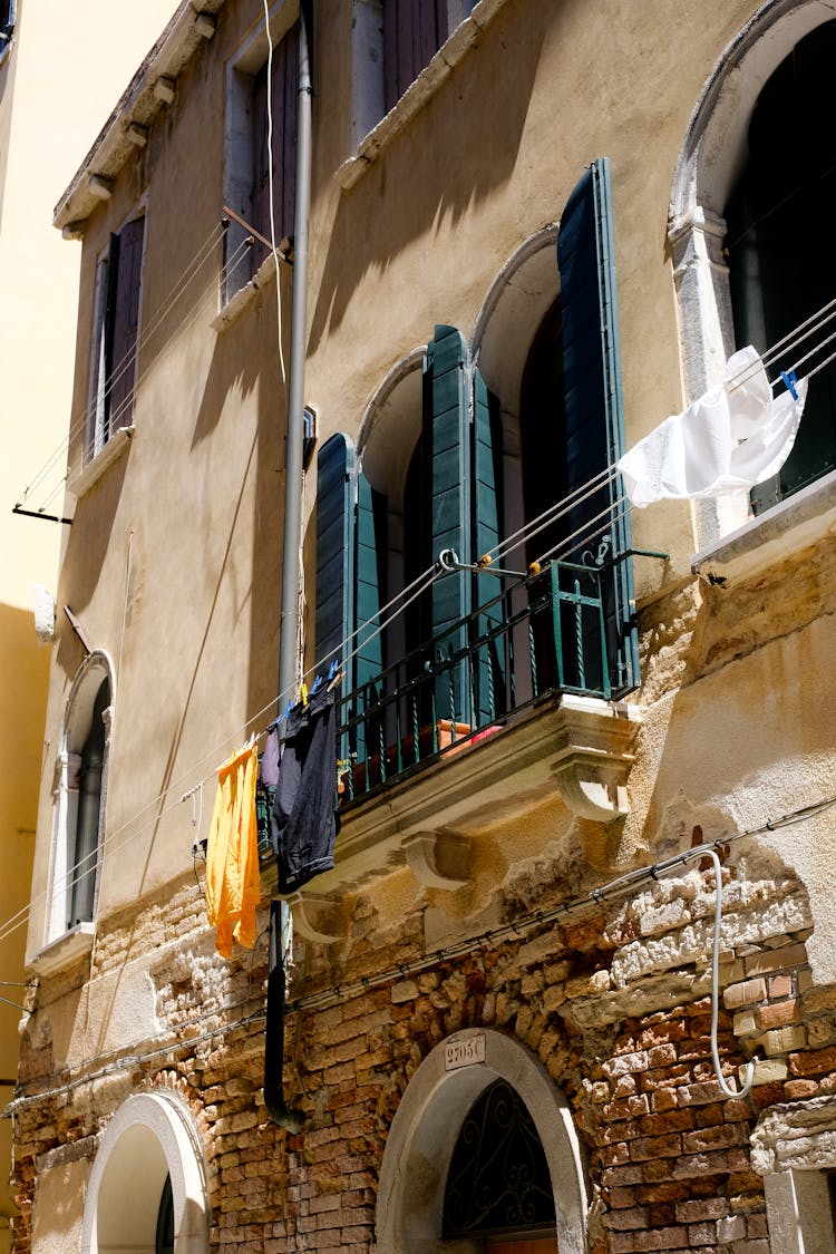 Clothes Hanging Outside Window Railing Of An Apartment Building