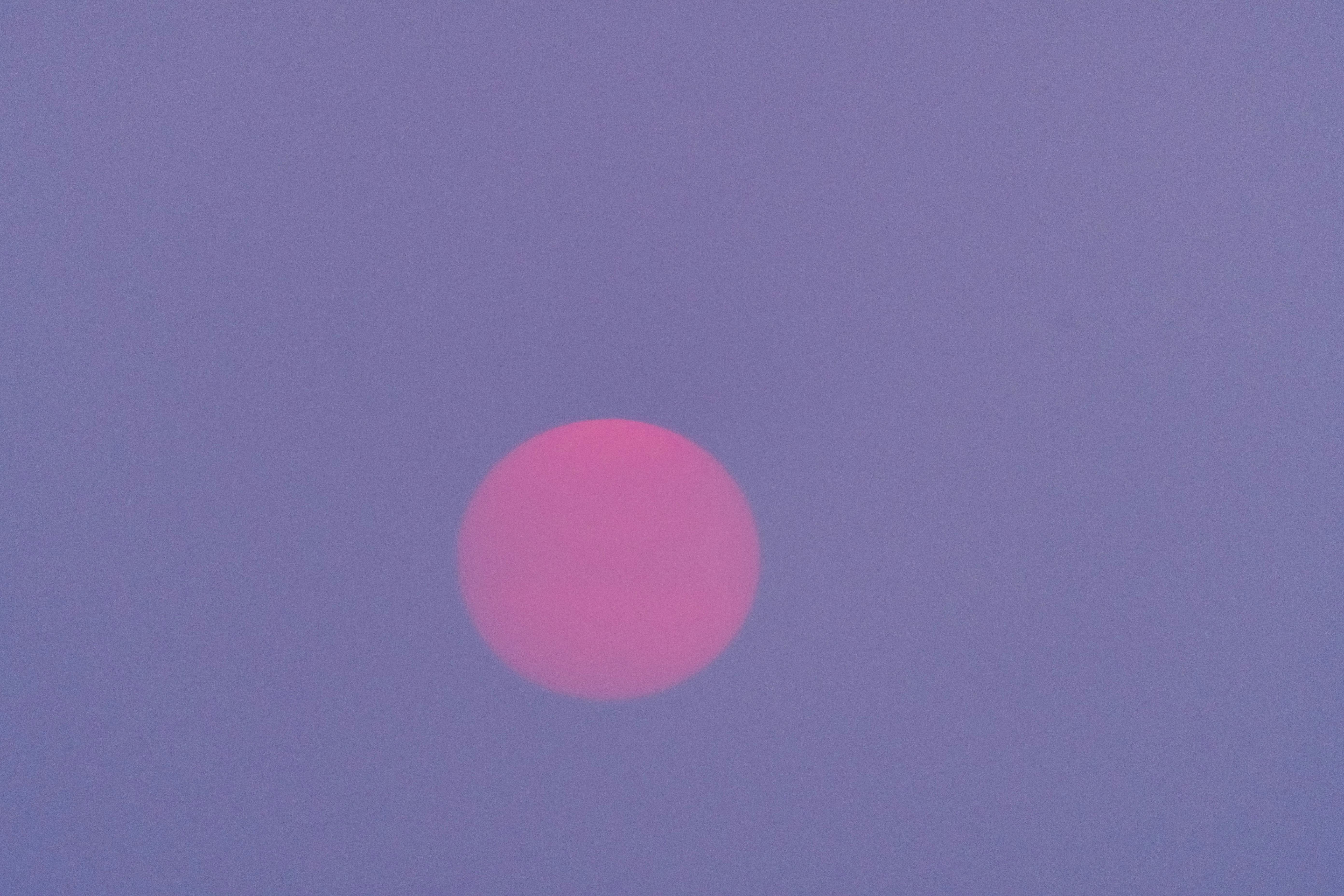 A striking red moon against a purple twilight sky, creating a mystical atmosphere.