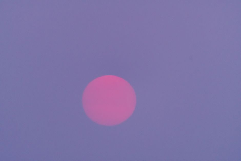 A striking red moon against a purple twilight sky, creating a mystical atmosphere.