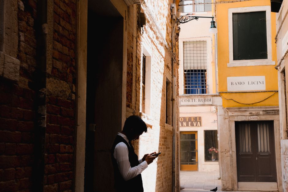 Traveler checking data usage on a smartphone app in front of an Italian landmark