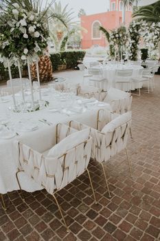 Beautifully arranged outdoor wedding venue with elegant table settings and floral decor.