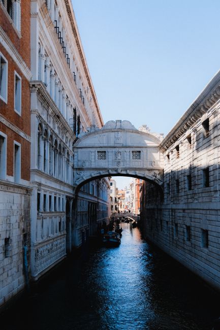 Captivating view of a Venetian canal at sunset with iconic historical architecture and a serene waterway.