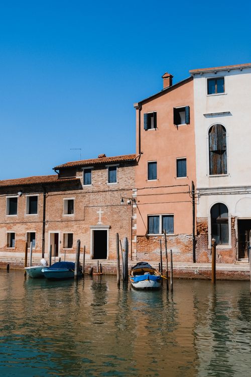 Free Historic Venetian buildings along a tranquil canal, capturing Italy's charm. Stock Photo