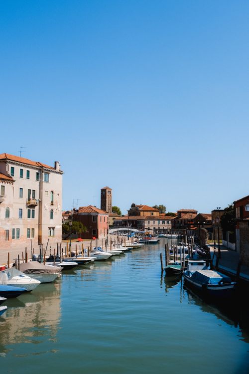 Free Beautiful sunny day view of a canal lined with boats in a historic European city. Stock Photo