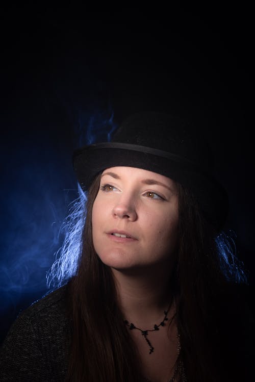 Portrait of a Woman Wearing a Black Cylinder Hat against Night Sky