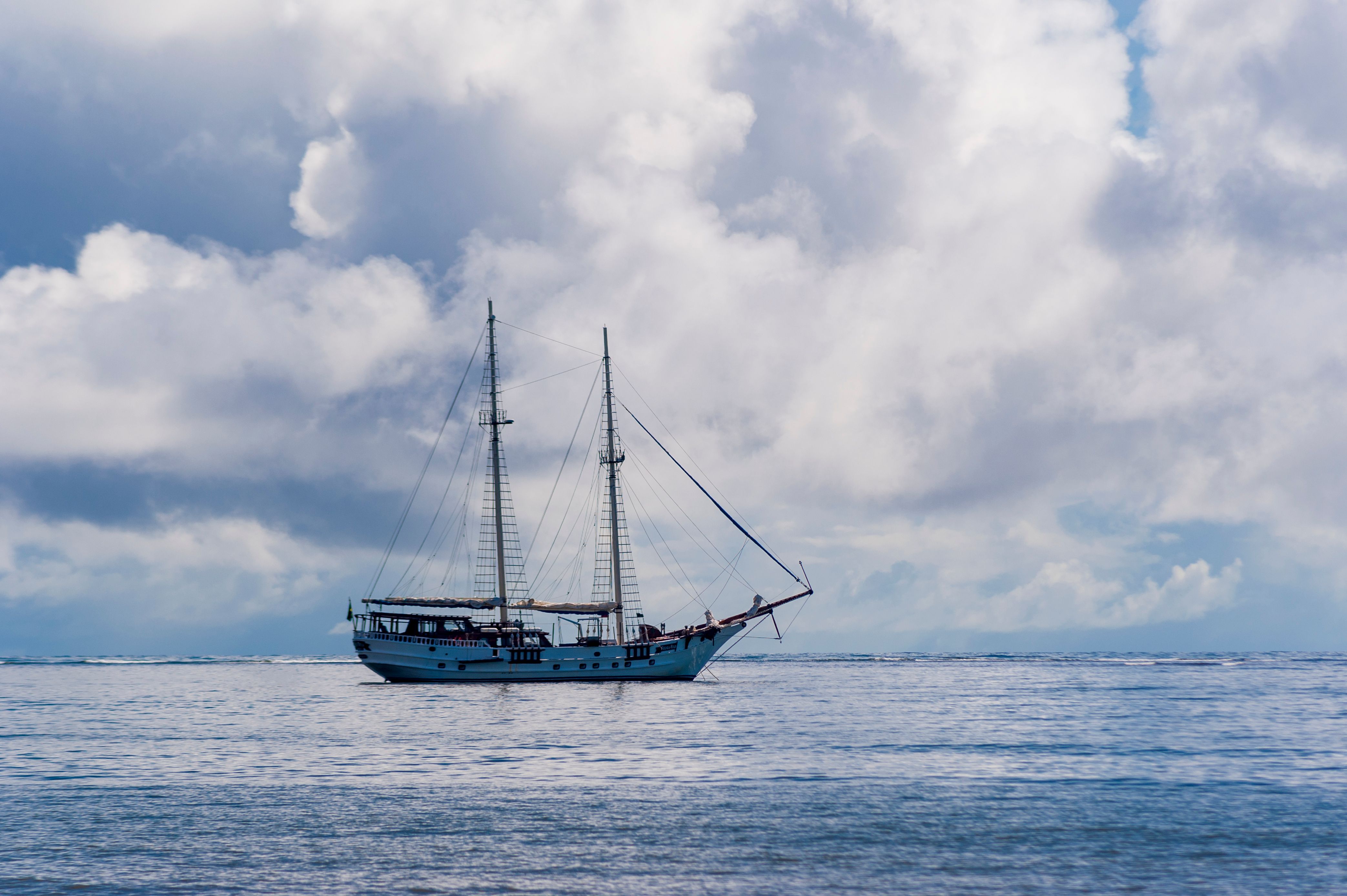 Best Luxury Diamond Head Sunset Sail Review: Hawaii's Most Romantic Evening on the Water Review 2026 - A picturesque sailing ship glides on a serene ocean, surrounded by dramatic clouds, perfect for travel and adventure themes.