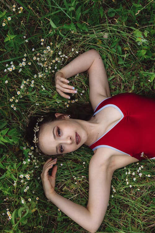 Woman in Red Tank Top Lying on the Grass