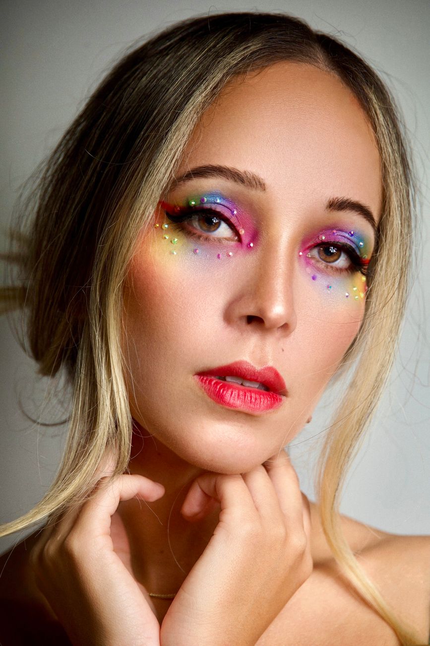 Colorful makeup portrait of a woman with vibrant eyeshadows and bold lips.
