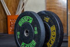 Heavy weight plates stacked in a rugged gym, ready for training.