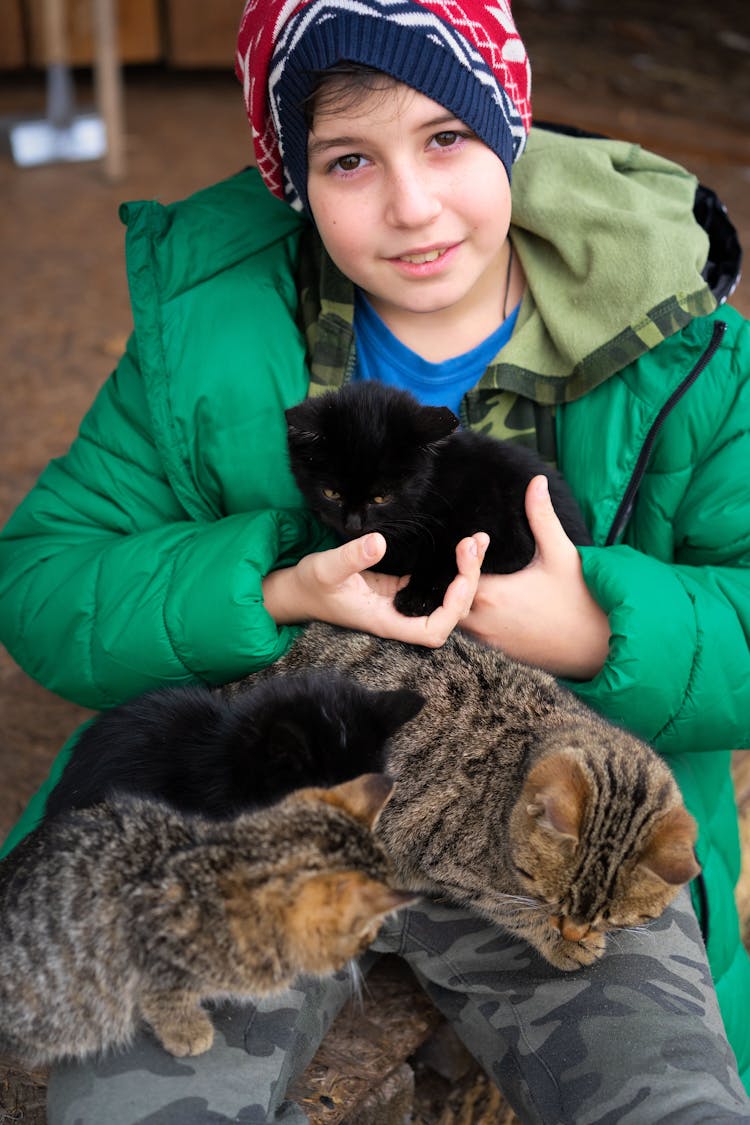 Photograph Of A Boy Holding A Black Cat