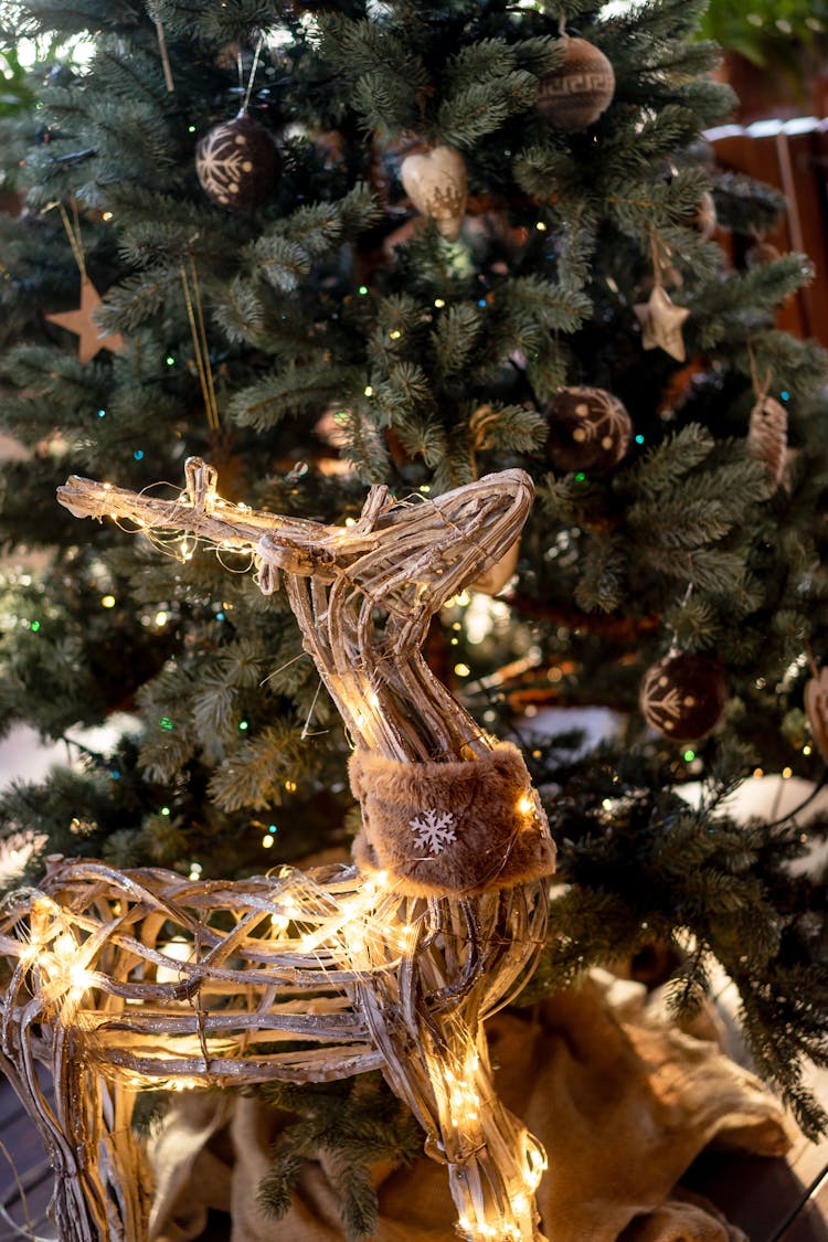 Wooden Deer Decoration Standing Under Christmas Tree