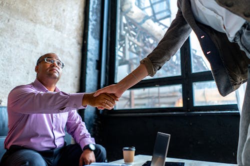 People Shaking Hands over Coffee Table