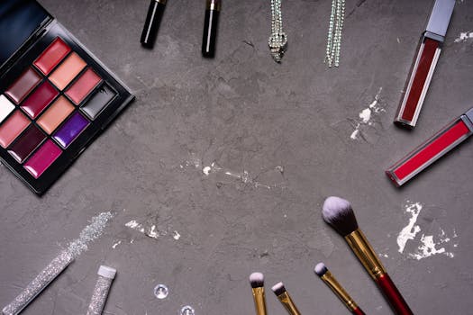 Stylish makeup arrangement featuring a diverse palette and brushes against a gray background.