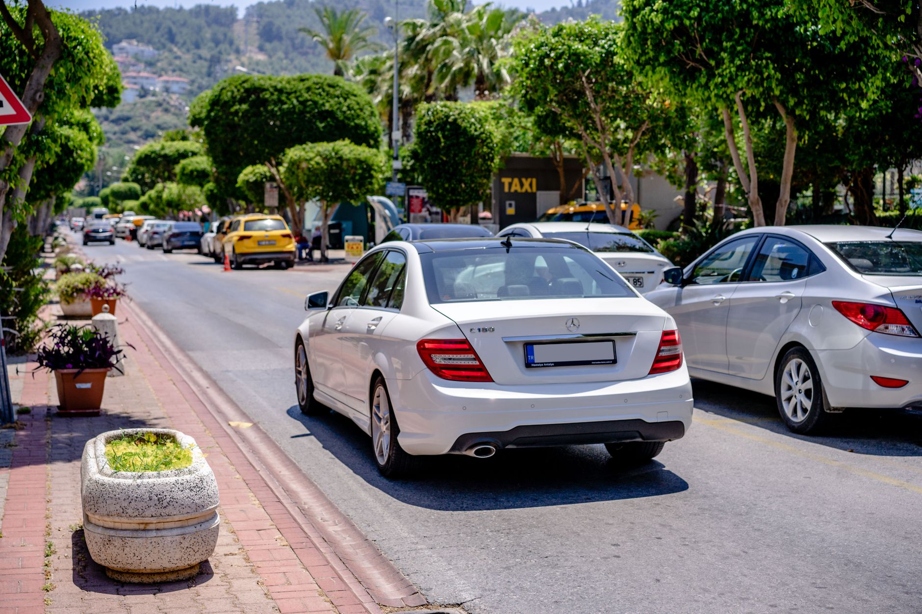 Hire car with red number plates on a Cyprus motorway with dry hills behind