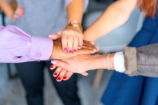 Close-up of diverse hands joined in a symbol of unity and teamwork.