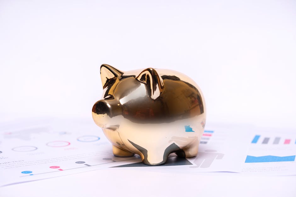 How Personal Capital Solves Net Worth Tracking for Busy Professionals Close-up of a golden piggy bank on financial documents, symbolizing savings and investment.