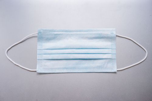 Free Close-up image of a blue surgical mask on a flat surface. Stock Photo