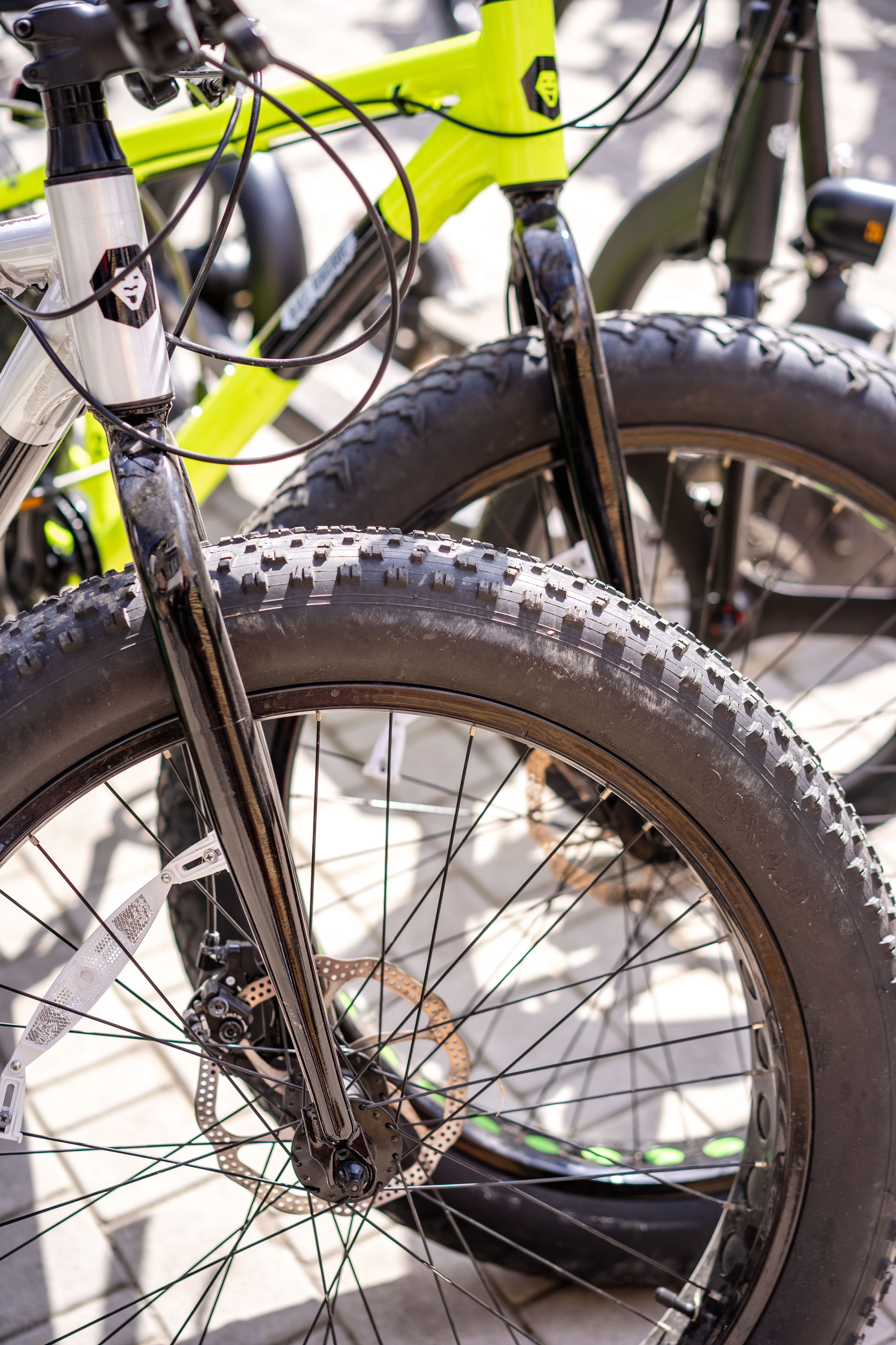 Detailed view of fat tire mountain bikes parked outdoors, showcasing robust design and engineering.
