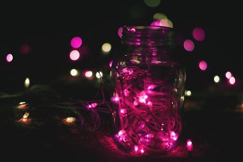 透明玻璃梅森罐子上的粉红色弦灯