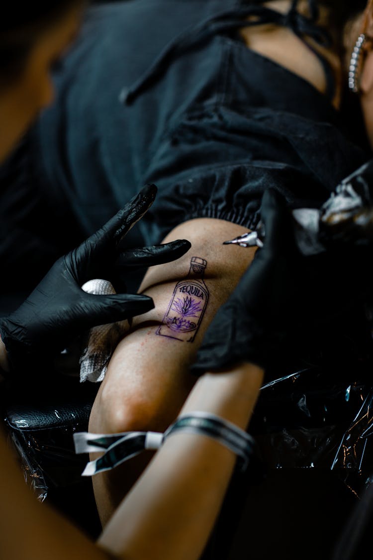 Hands Of A Person Tattooing An Arm