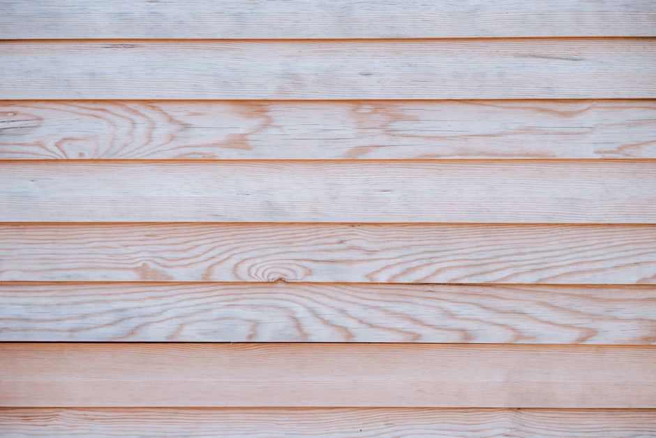 Close-up of a light wooden wall showcasing a natural grain pattern and texture, ideal for design backdrops.