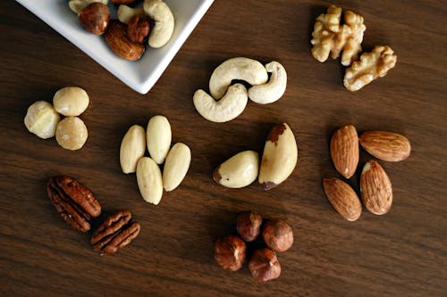 Free Variety of Brown Nuts on Brown Wooden Panel High-angle Photo Stock Photo