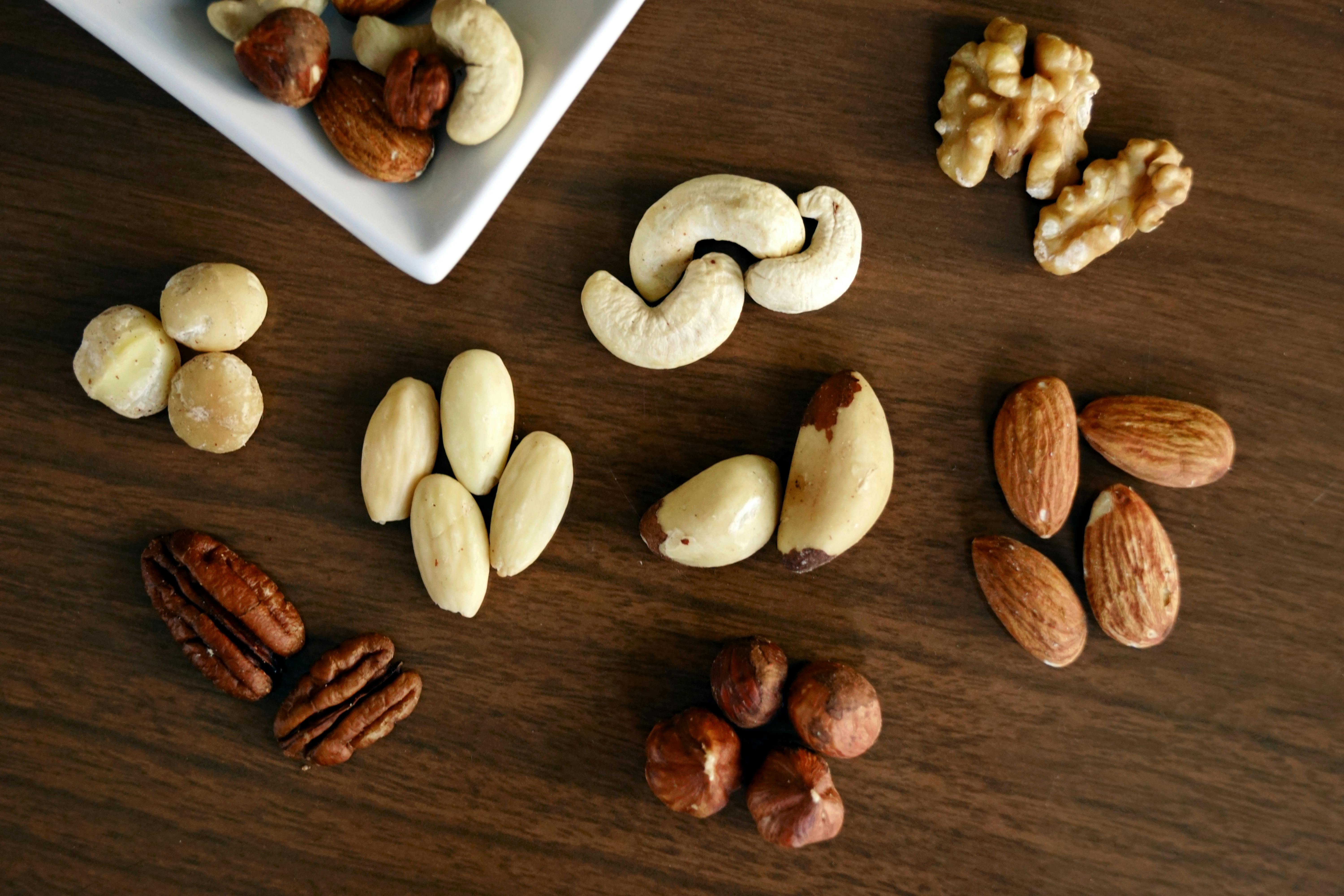 Variety of Brown Nuts on Brown Wooden Panel Highangle Photo · Free
