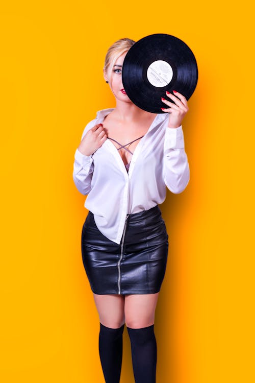 Woman Posing in Studio Holding a Vinyl Record · Free Stock Photo