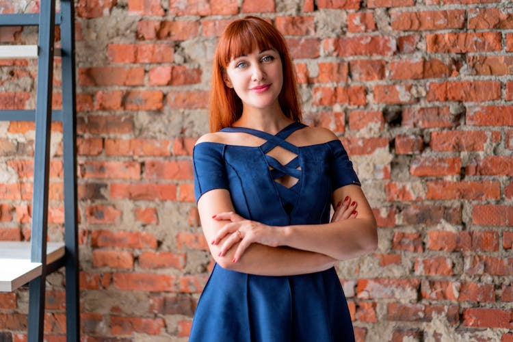 Woman In Blue Dress With Arm Crossed