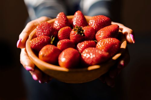 Free Close-up of a bowl filled with fresh, juicy strawberries held in hands, perfect for healthy eating themes. Stock Photo