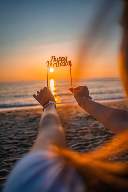 Woman Holding Happy Birthday Frame on Beach