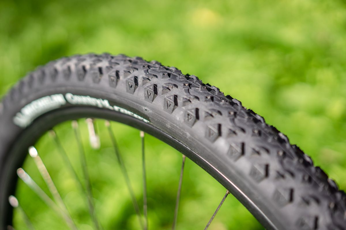 Mountain bike wheel with tubeless tire setup showing sealed rim and valve stem