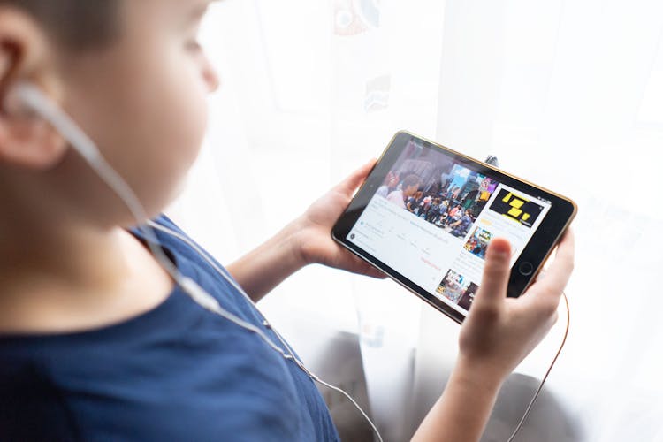 A Kid Holding Black Tablet Computer