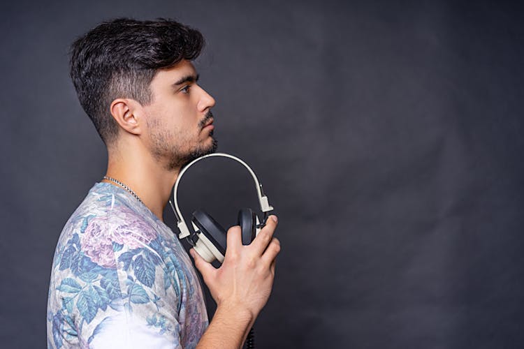 Man In Floral Shirt Holding A Headphone
