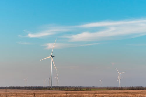 Wind Turbines on Brown Field Under Blue Sky