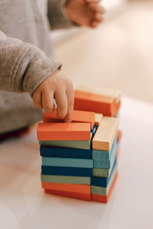 Child Hand on Colorful Blocks