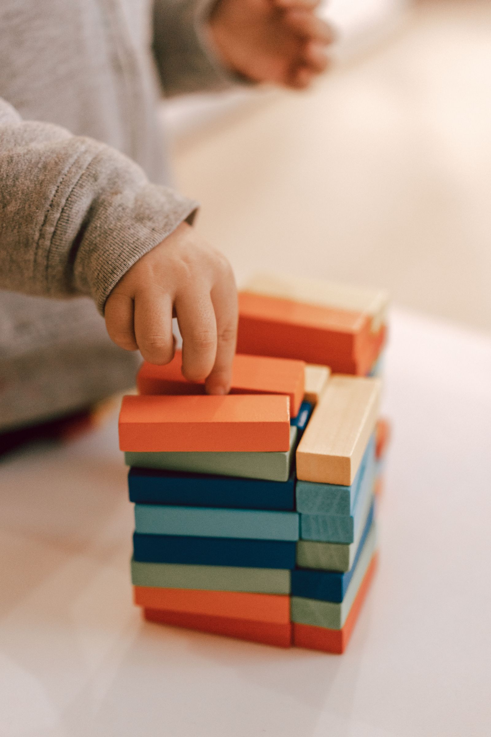 A child stacking colourful wooden blocks