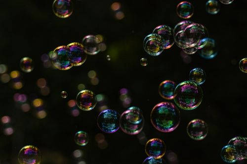Free Close-up of colorful soap bubbles floating against a dark background, showcasing iridescent reflections. Stock Photo
