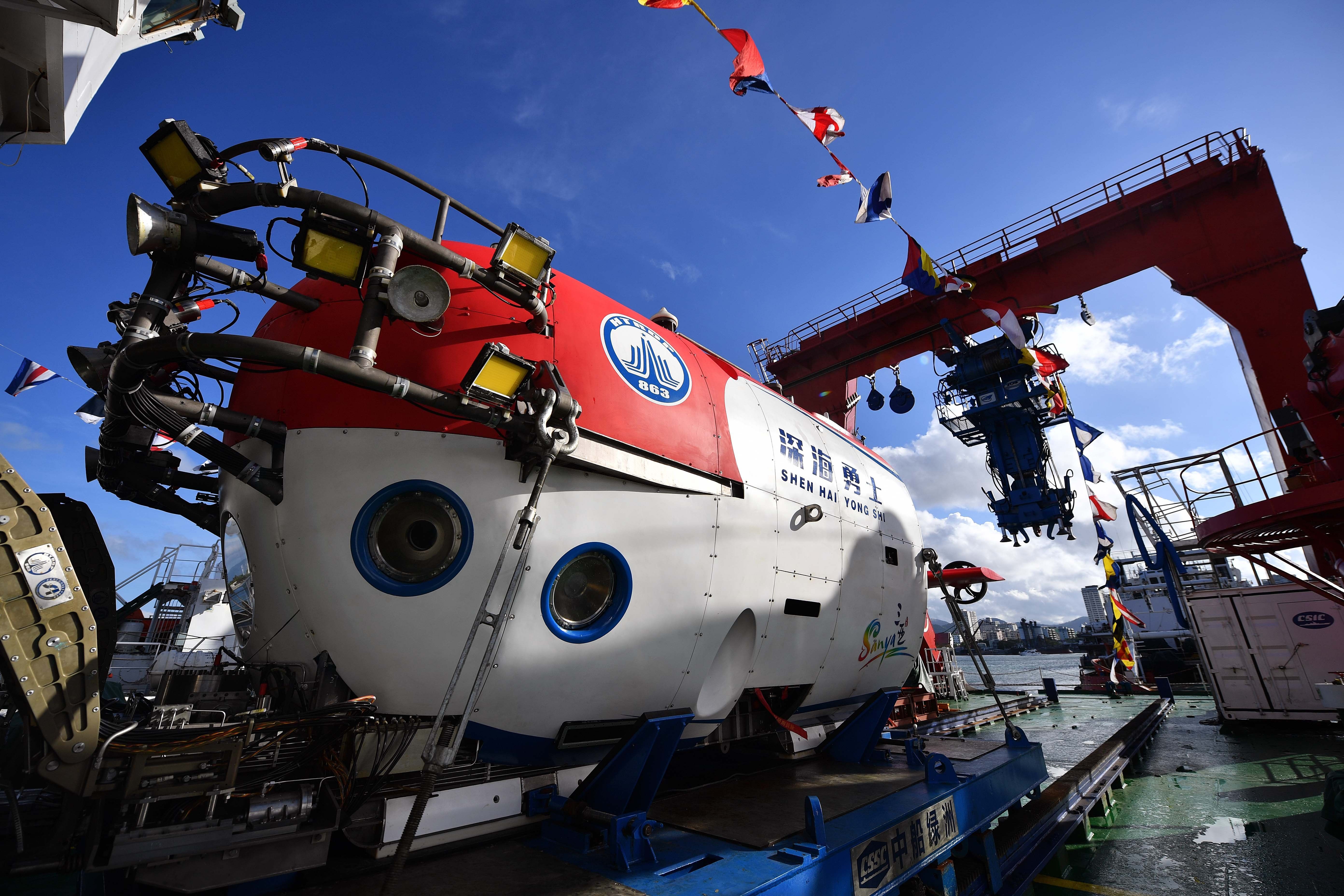 A close-up view of a submarine on a dock, under a clear blue sky.
