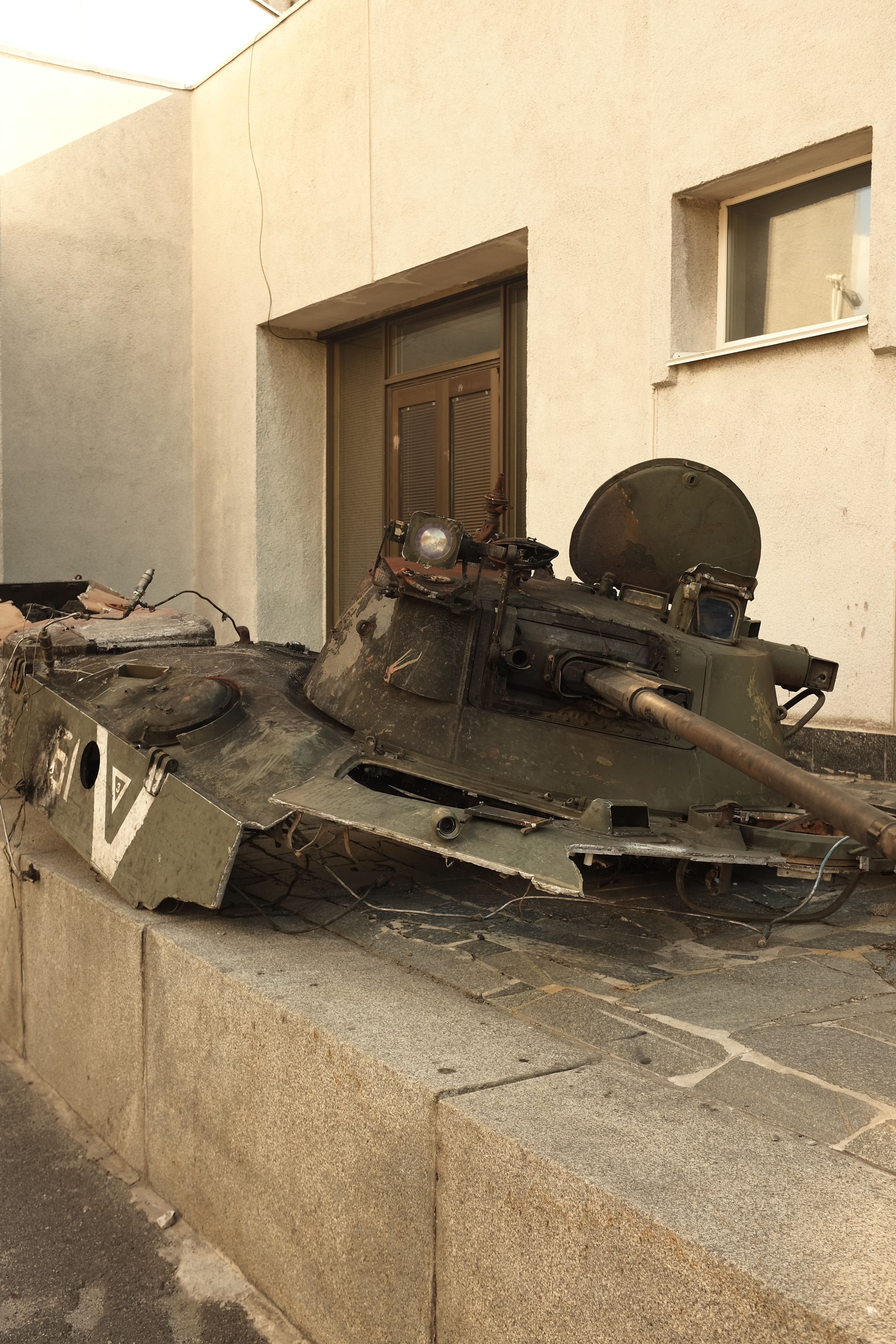 A rusted military tank turret lies abandoned in Kyiv, Ukraine, symbolizing war's impact.