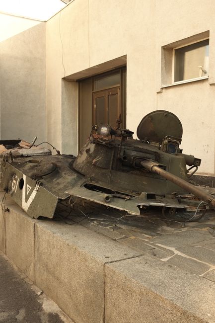 A rusted military tank turret lies abandoned in Kyiv, Ukraine, symbolizing war's impact.