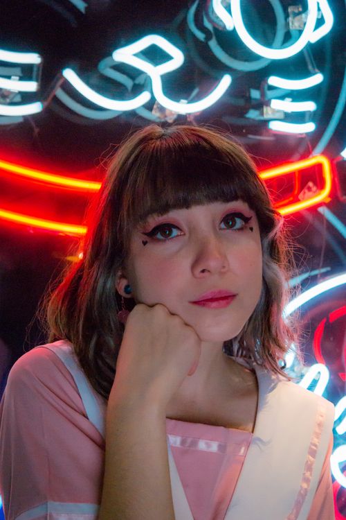 Free Portrait of a woman in front of colorful neon signs at night in Ciudad de México. Stock Photo