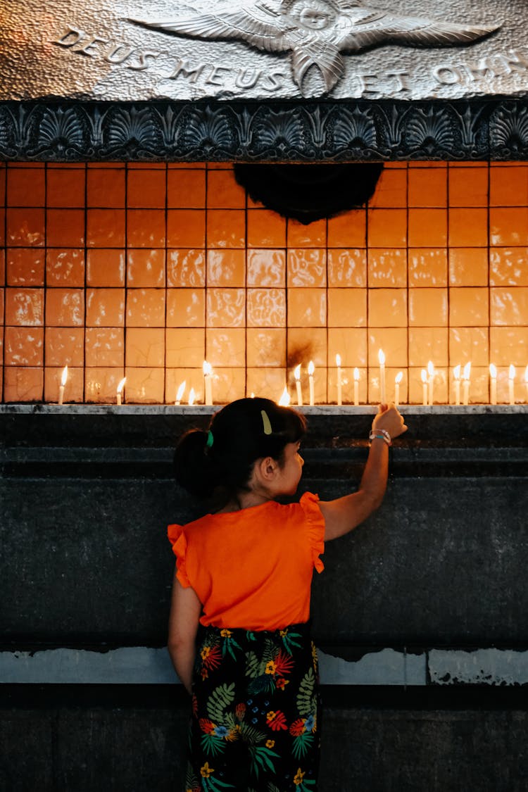 Back View Of A Kid Near Lit Candles